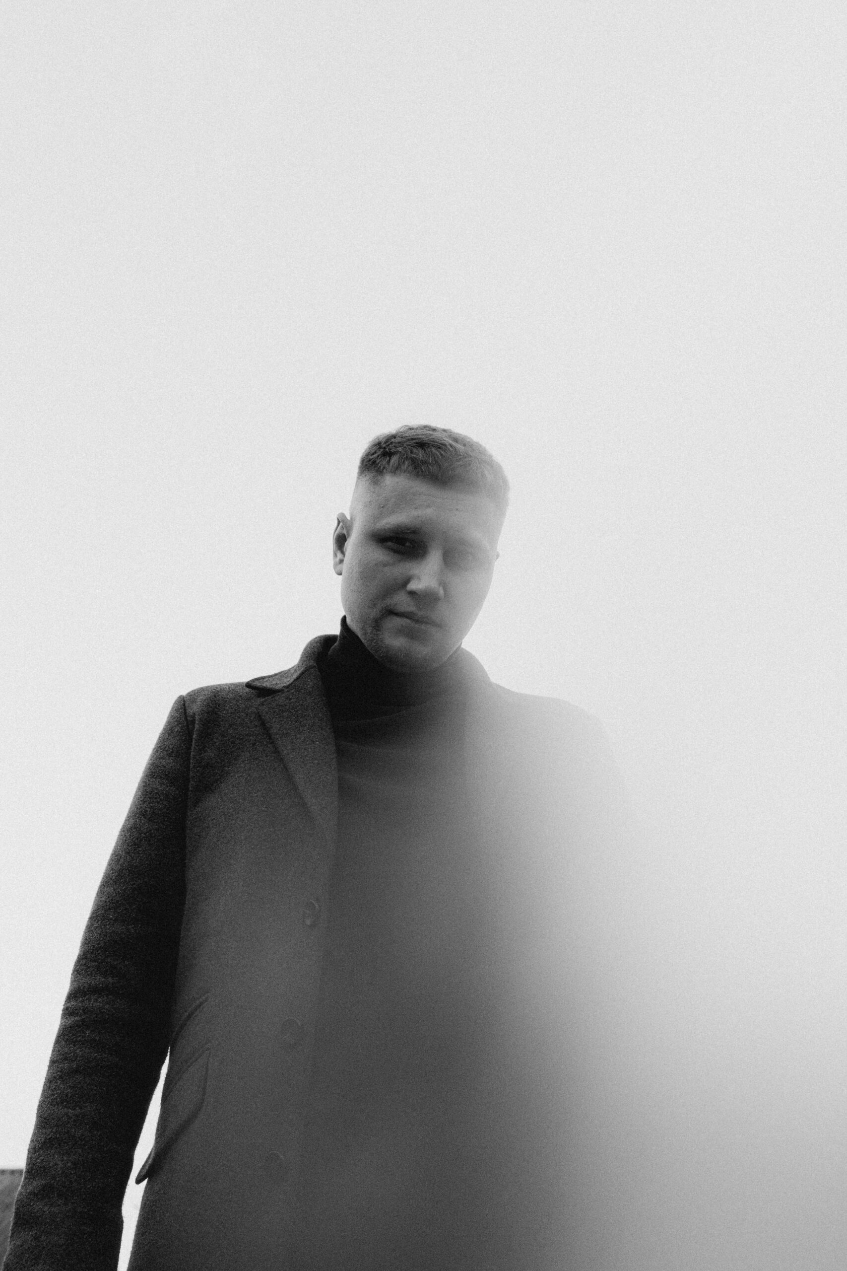 Artistic monochrome portrait of a man wearing a coat, photographed in Vitebsk, Belarus.
